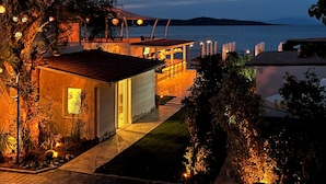 A coastal property with a patio, outdoor seating, and a view of the sea.