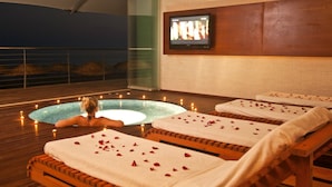 Un espacio de spa con piscina, sillones de masaje y una pantalla de televisión.