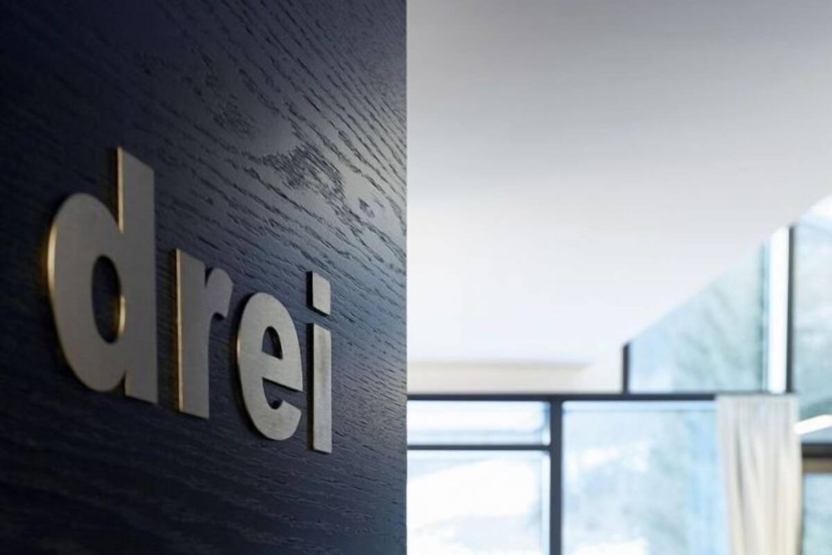 A modern interior with a dark wooden wall and a sign reading "drei".