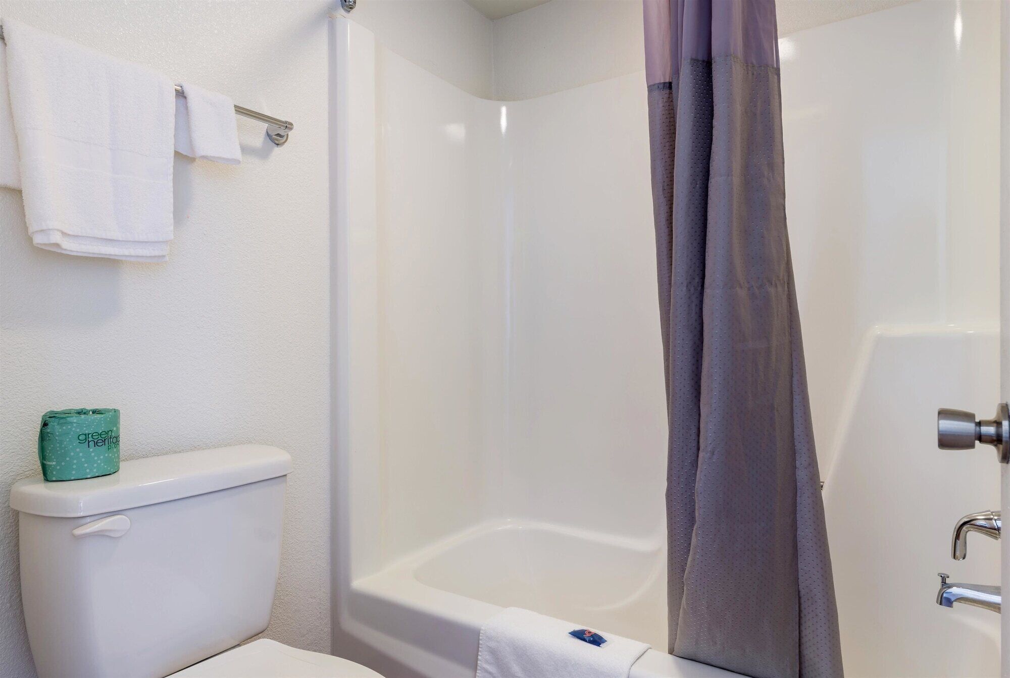 Een badkamer met toilet, bad en douchegordijn.