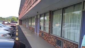 A building with a row of parked cars and a brick facade. - Motel 6 Connellys Springs, NC (Icard)