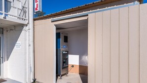 A small, single-story building with a beige exterior and a partially open door. - Motel 6 Connellys Springs, NC (Icard)