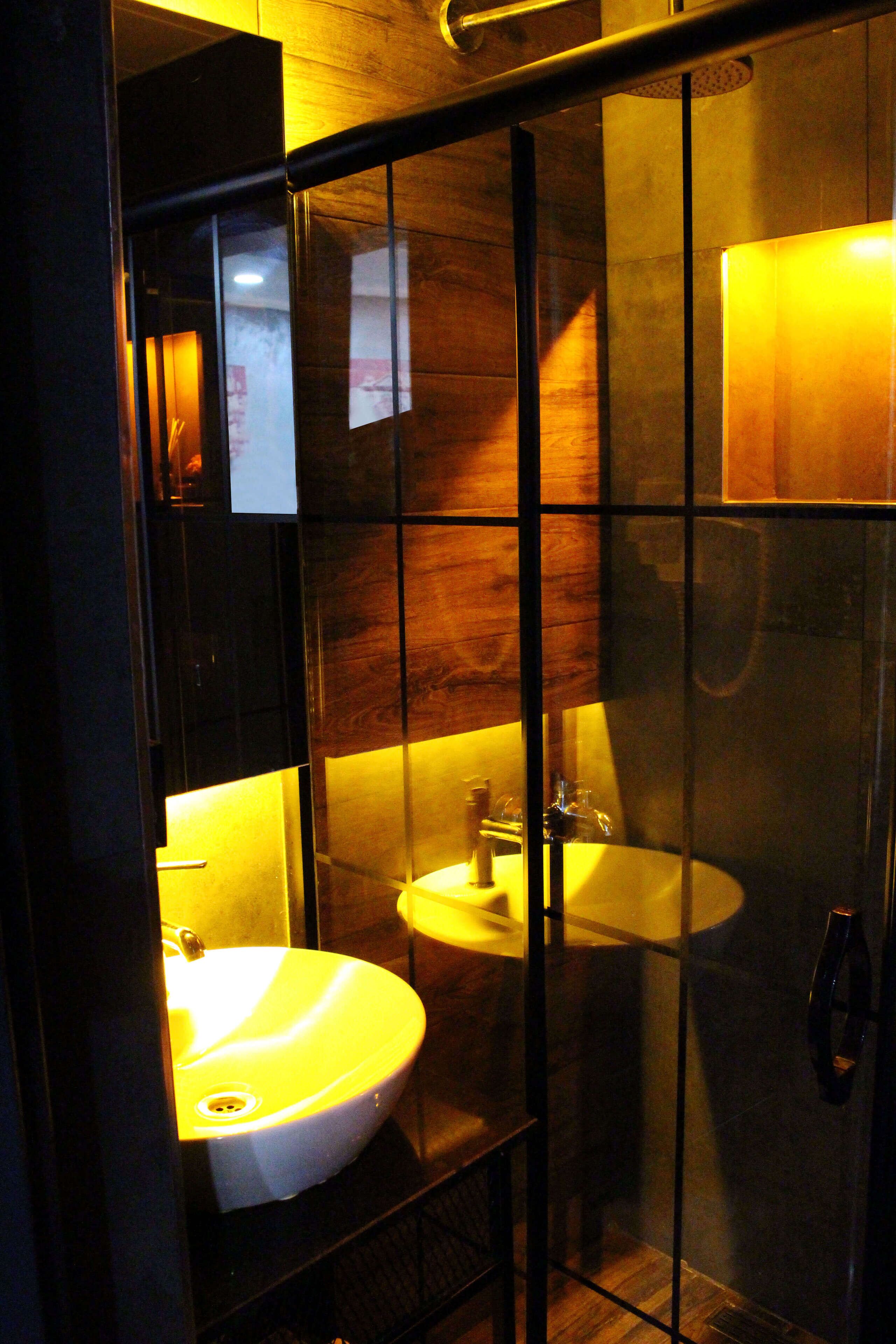 Une salle de bain moderne avec une paroi en verre, un lavabo et un miroir.