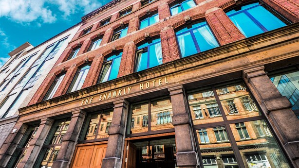 The Shankly Hotel with a classic brick facade and large windows.