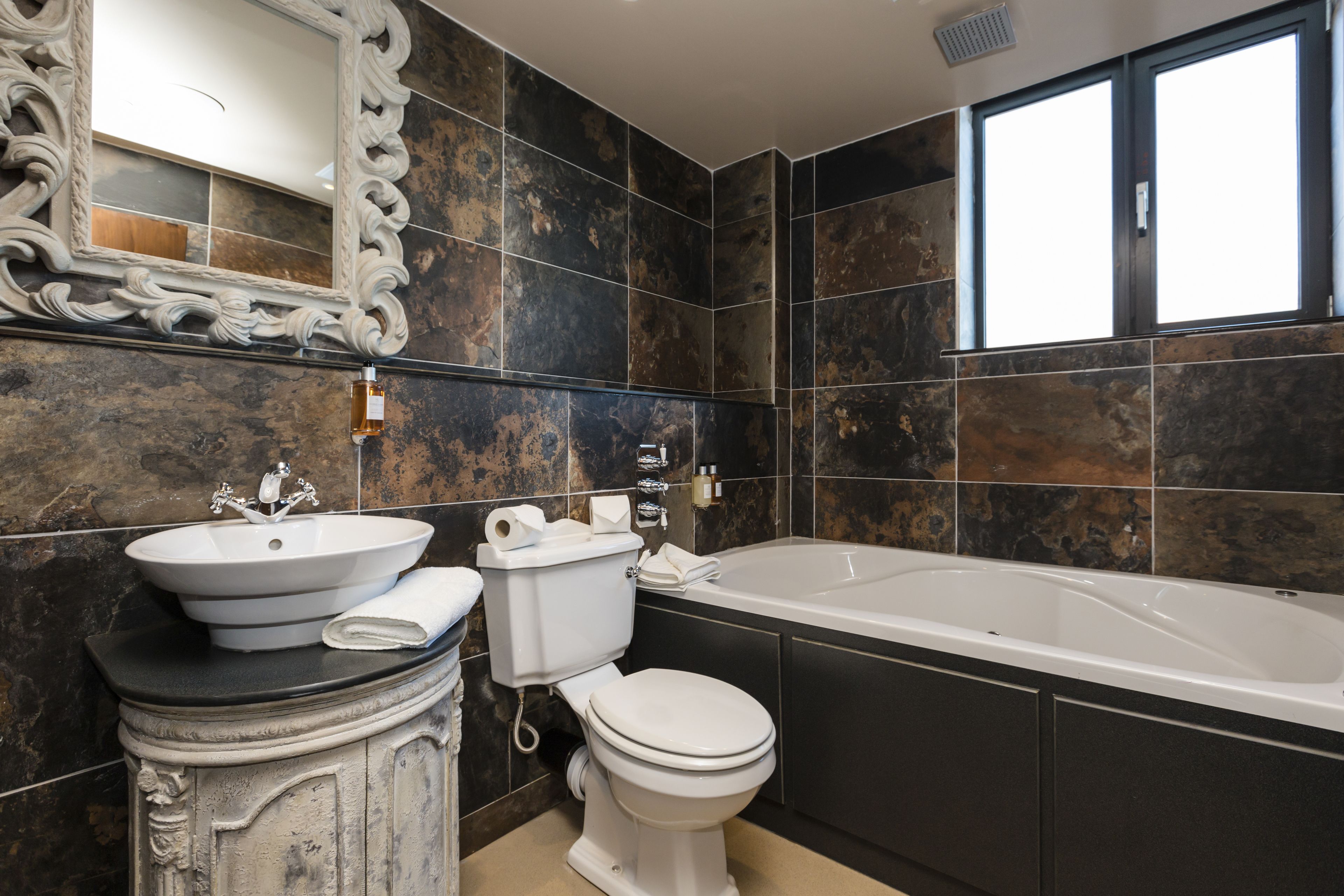 Un baño moderno con lavamanos, inodoro y bañera.