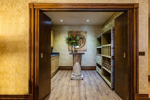 A hallway with wooden flooring, a wooden door frame, and a mirror on the wall.