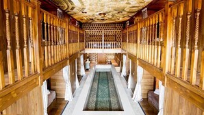 A long, narrow hallway with wooden railings and a central water feature.