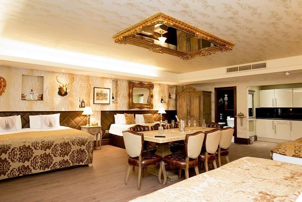 Une chambre d’hôtel luxueuse dotée d’un grand lit, d’un coin repas et d’une cuisine.
