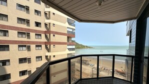 A balcony with a view of a beach and a high-rise building. - Guarapari Praia (Guarapari)