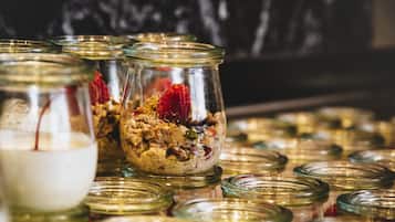 Varios frascos de vidrio con tapas, algunos conteniendo alimentos, dispuestos sobre una superficie.