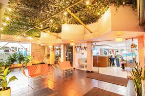 A lobby with a reception desk, seating area, and potted plants. - Hotel Taybo Beach (Santa Marta)