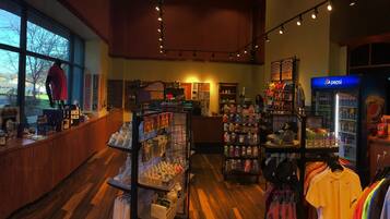 A store with a variety of items on shelves and racks, including snacks, souvenirs, and clothing.