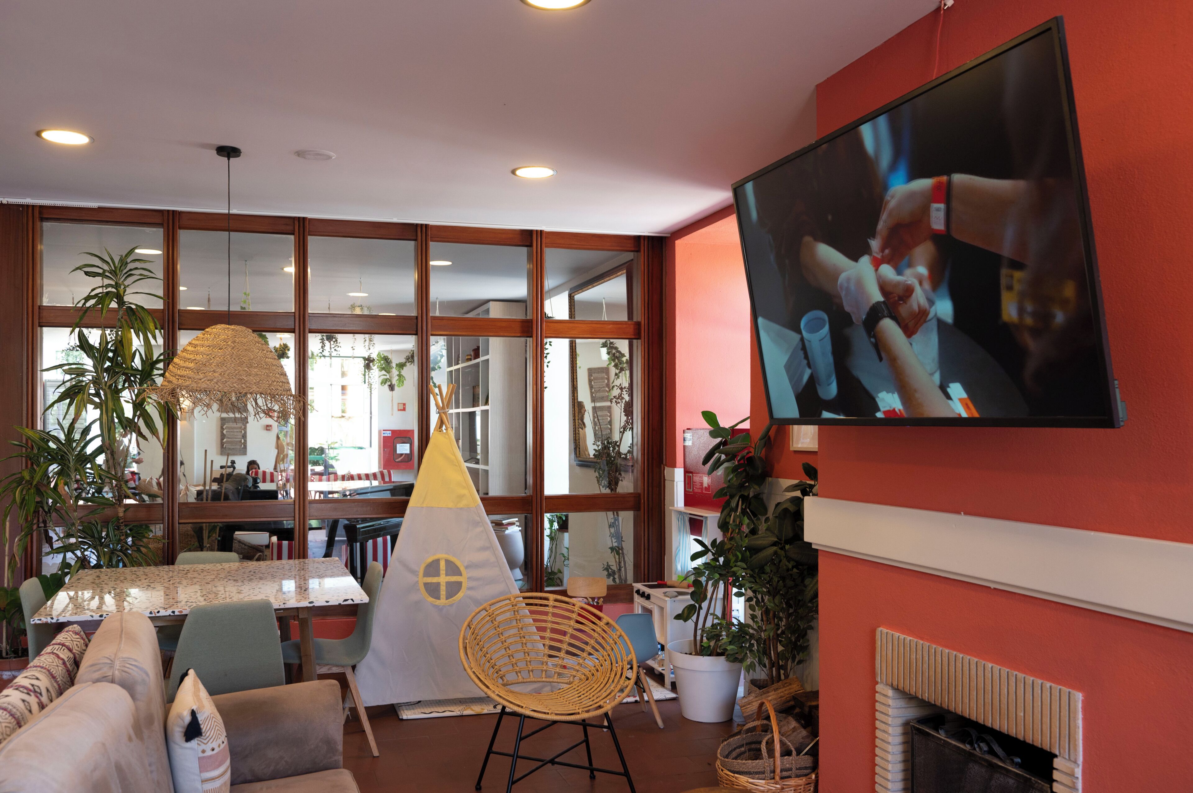 A modern interior with a large TV, a dining area, and a cozy seating space.