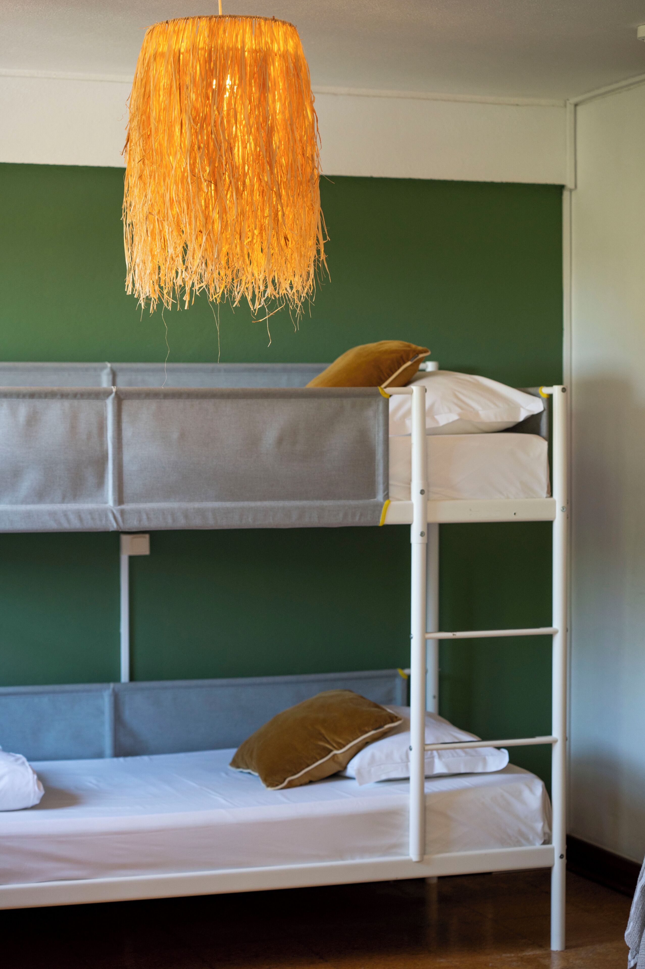 Una cama litera con una lámpara colgante encima.