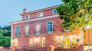 A pink building with the sign "SARRAZOLA HOUSE A.L." It has multiple windows, a balcony, and a staircase leading to the entrance. - WOT Sarrazola Soul (Sintra)