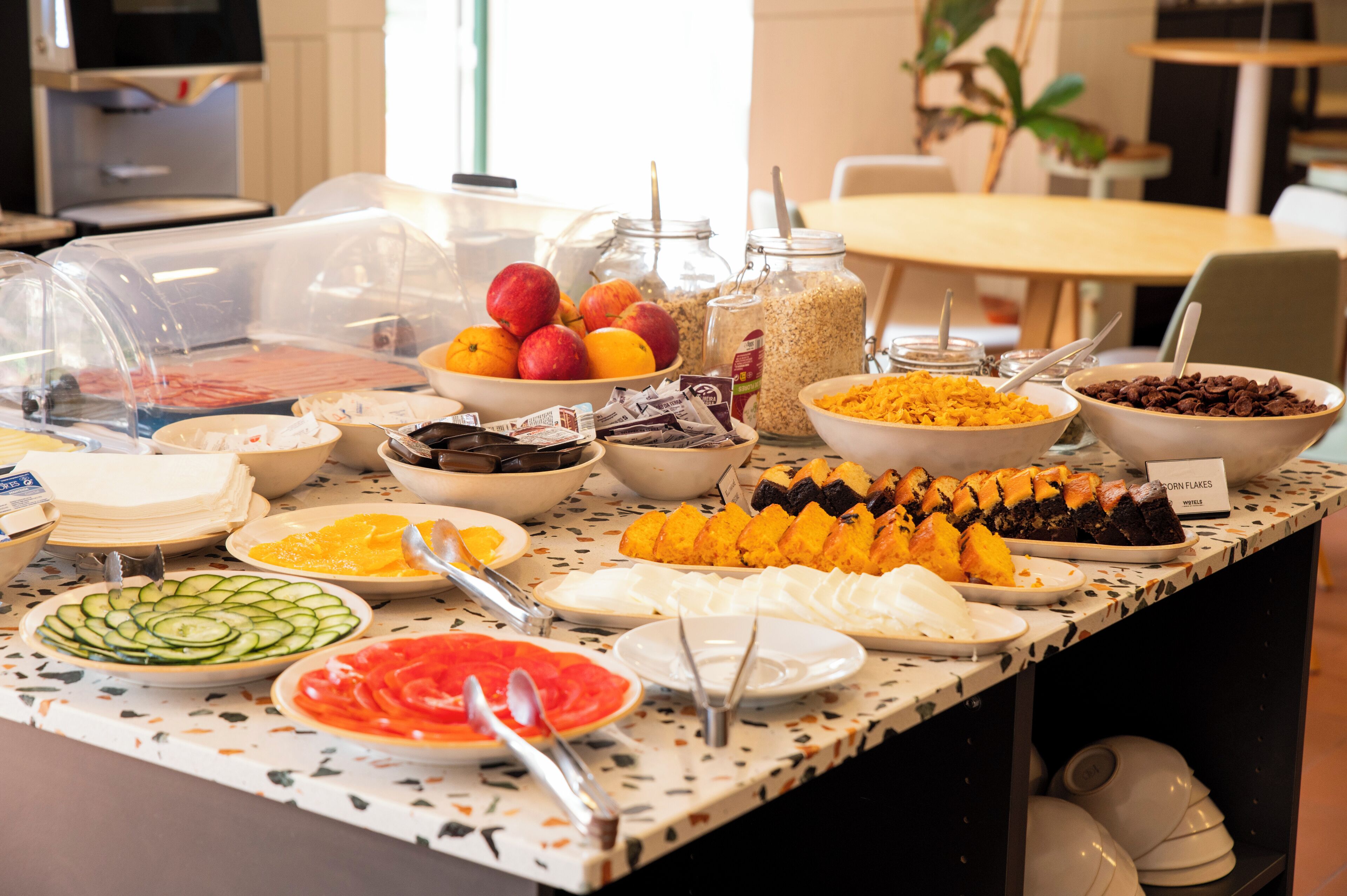 A buffet with various food items including fruits, cereals, and vegetables.
