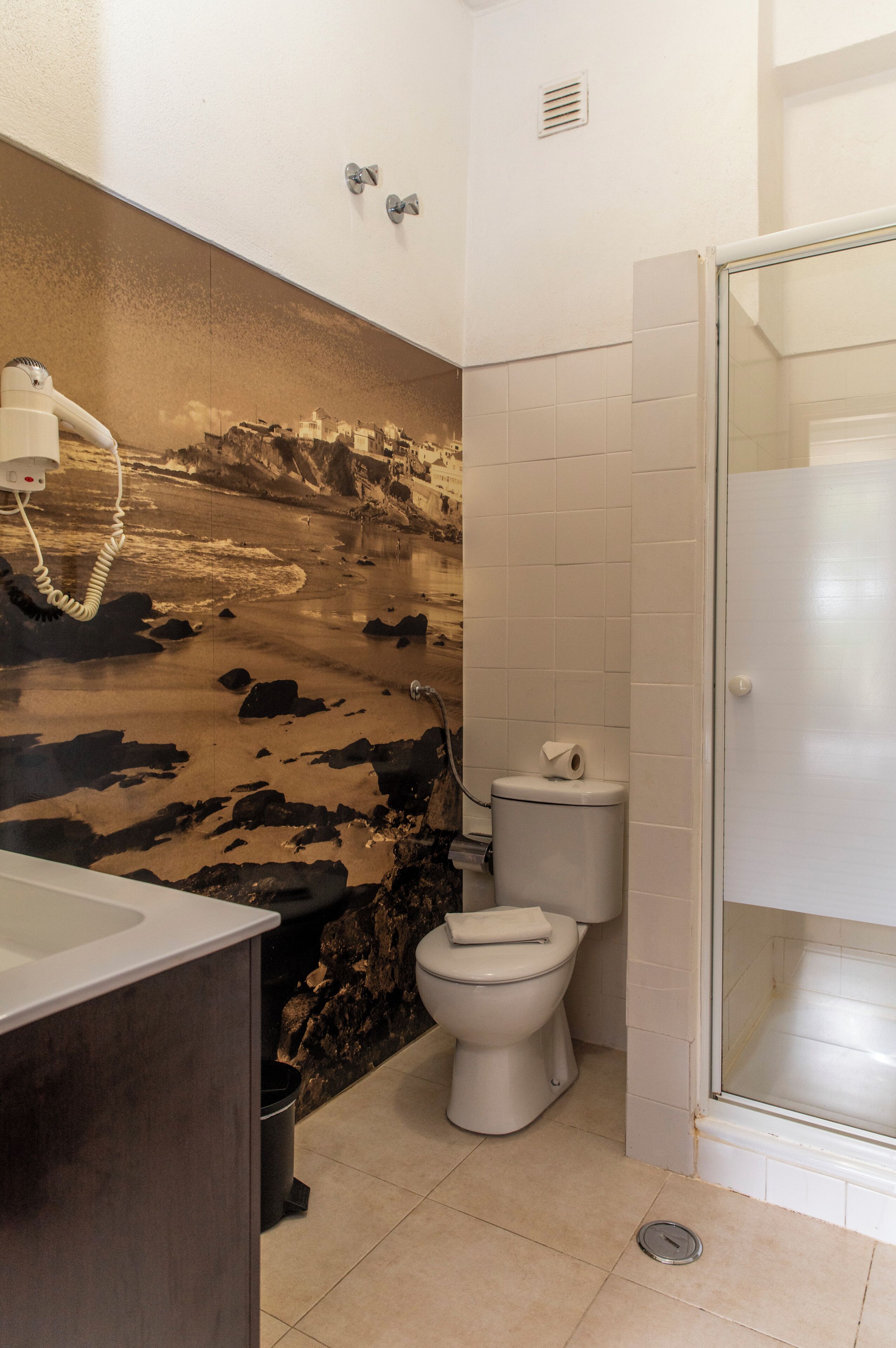 Un baño con lavamanos, inodoro y ducha.