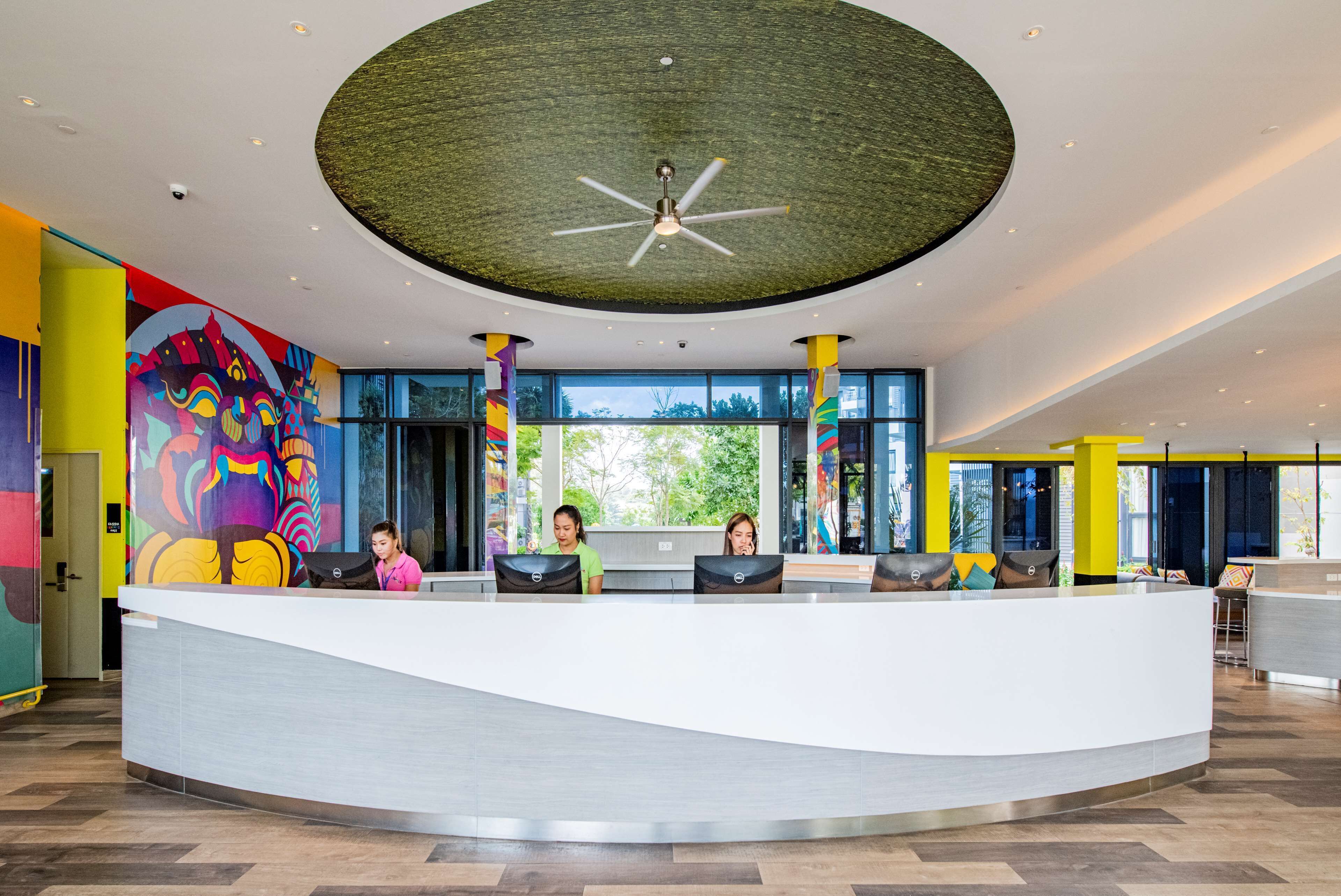 A modern reception area with a curved desk, large windows, and a ceiling fan.