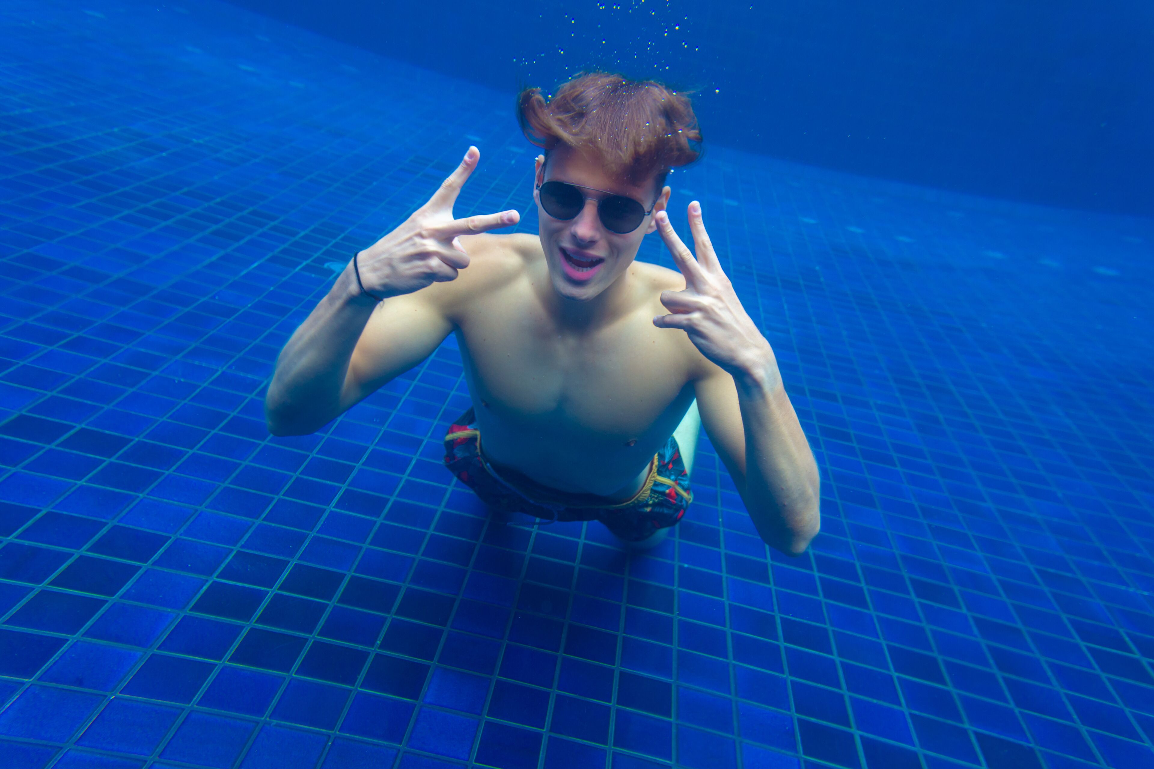 Una persona en una piscina con piso de baldosas.
