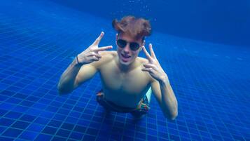 Una persona en una piscina con piso de baldosas.