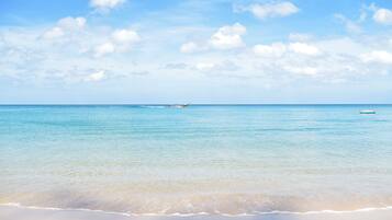 Privéstrand vlakbij, wit zand, ligstoelen aan het strand, parasols