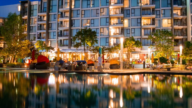 Un hotel moderno con una piscina que refleja el edificio.
