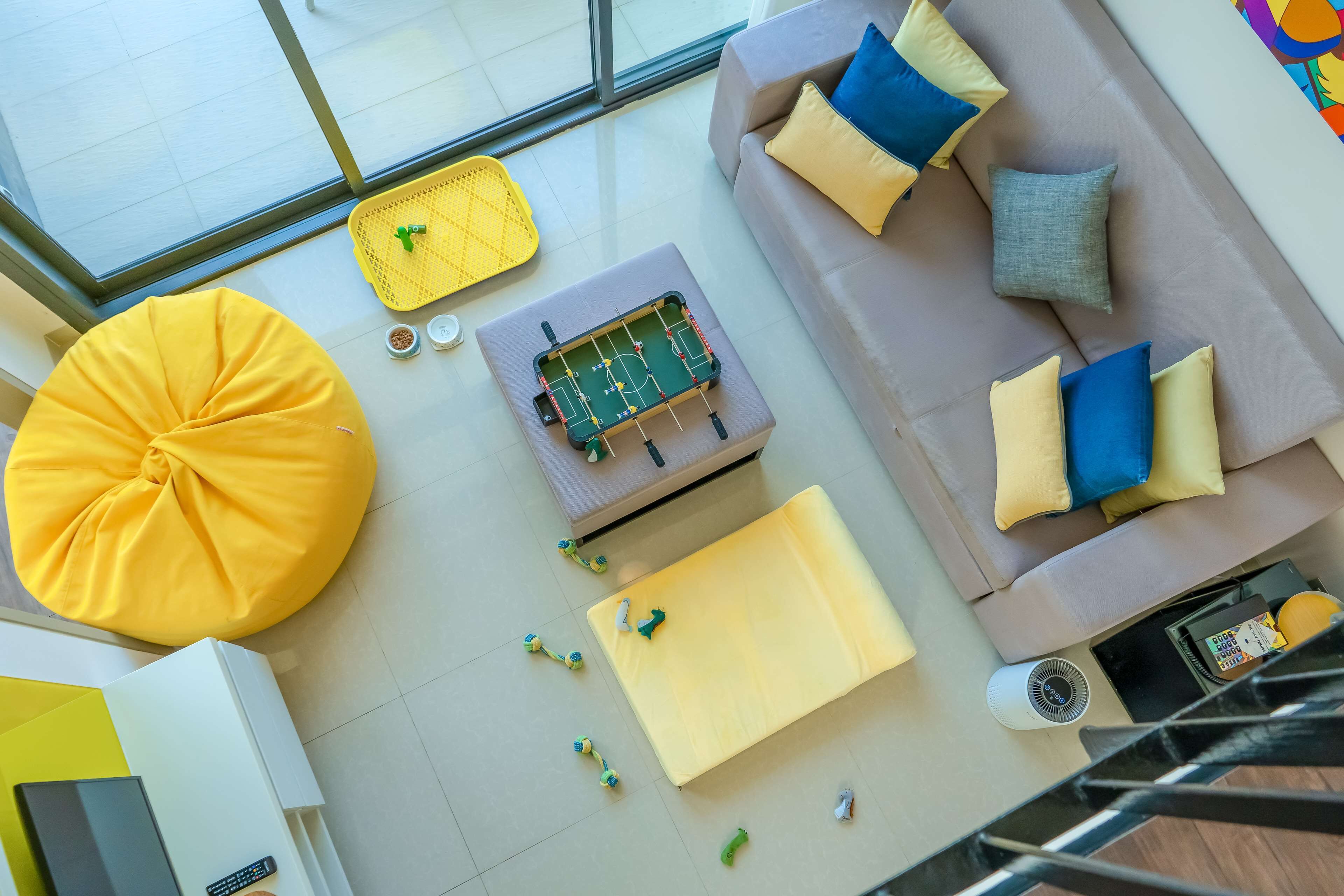 Een moderne woonkamer met een bank, een poef en een bijzettafeltje met een spel.