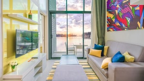 A modern living room with a TV, sofa, and artwork.
