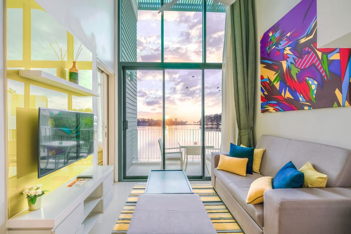A modern living room with a TV, sofa, and artwork.