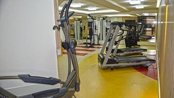 Een sportschool met loopbanden, elliptische trainers en gewichten.