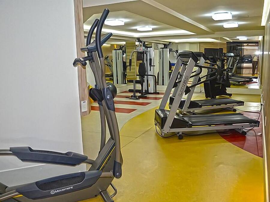 Een sportschool met loopbanden, elliptische trainers en gewichten.