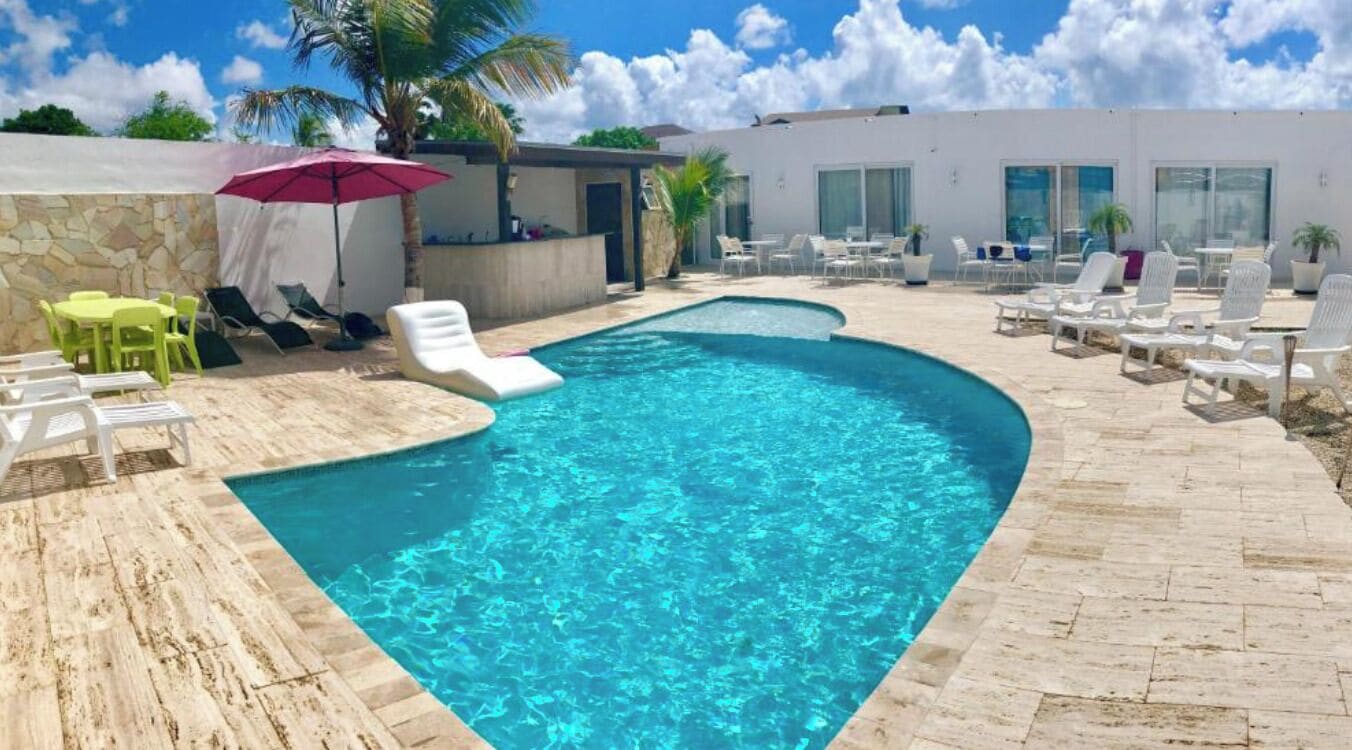 Una piscina al aire libre, sillones reclinables de piscina