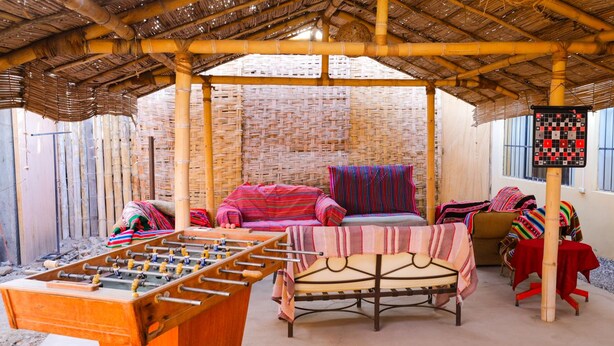 A cozy indoor setting with a foosball table, comfortable seating, and a traditional woven wall. - Nasca Trails B&B (Nazca)