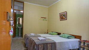 A hotel room with two beds, a sink, and a painting on the wall. - Nasca Trails B&B (Nazca)