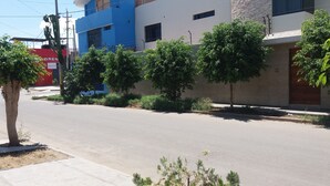 A street with buildings, trees, and a clear sky. - Nasca Trails B&B (Nazca)