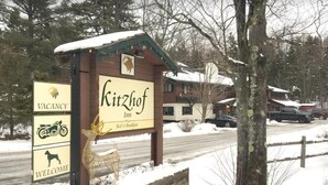 Señal del Hotel Ritzhof que indica disponibilidad y símbolos de bienvenida, una escultura de ciervo y un tejado cubierto de nieve.