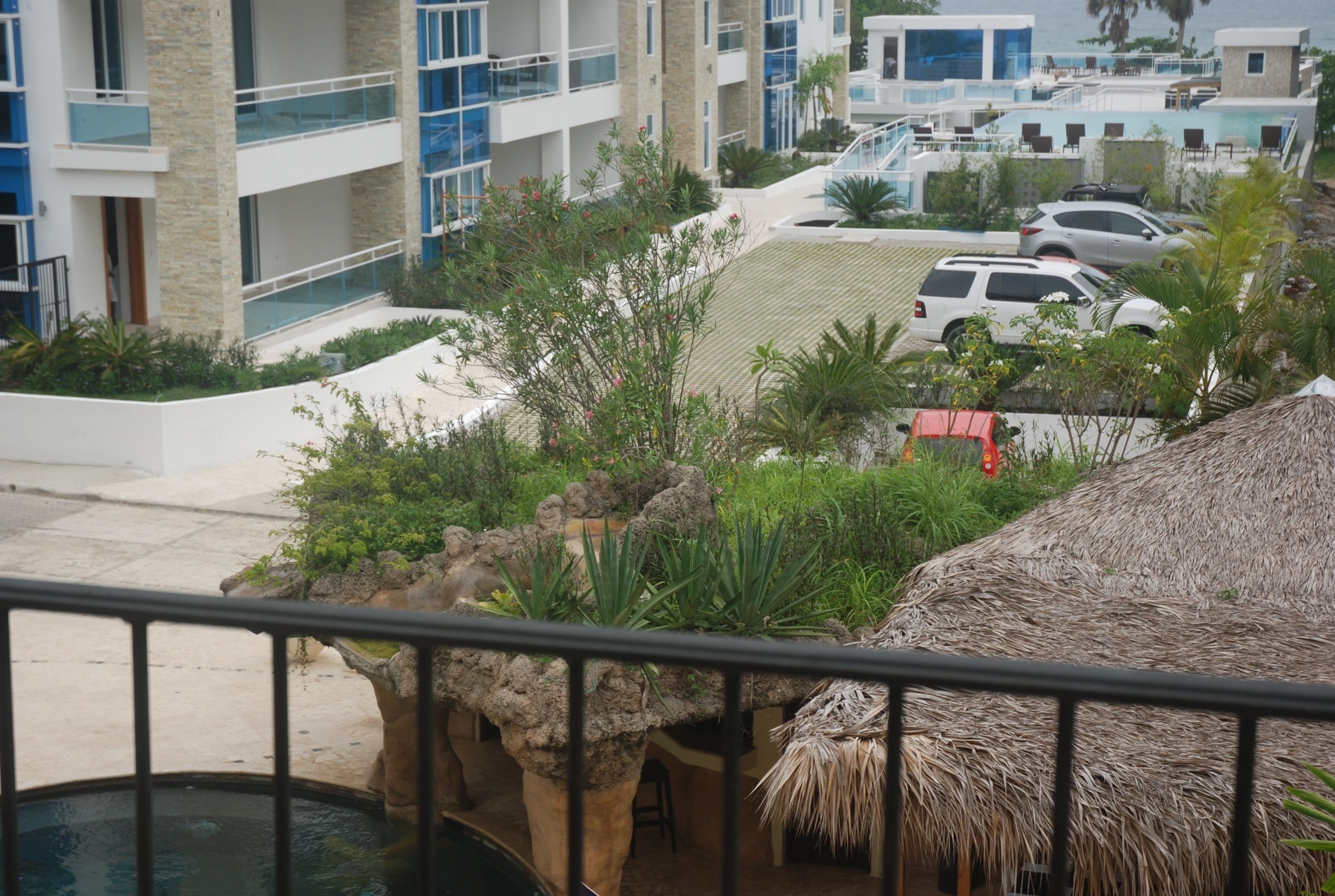 A modern hotel with a pool, outdoor seating, and a view of the surrounding area.