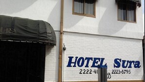 Un bâtiment sur lequel on peut lire l’inscription « HÔTEL Sura » et où figurent deux numéros de téléphone.