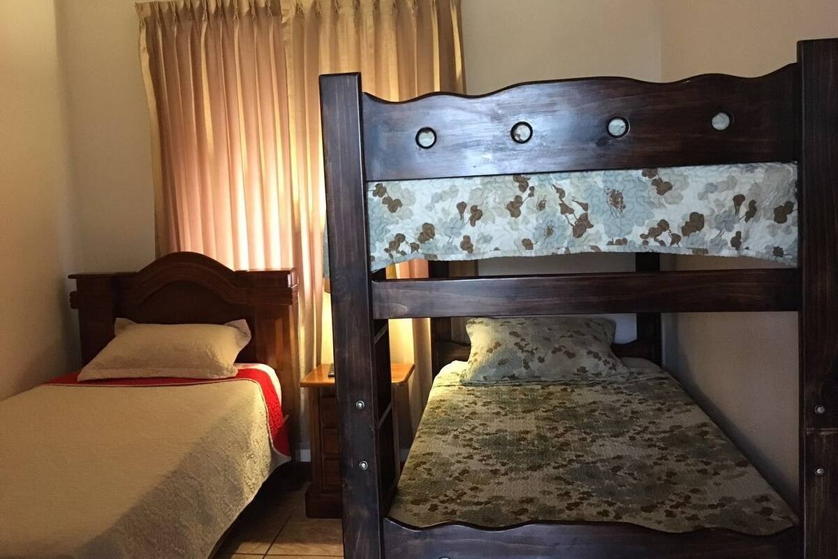 Un lit superposé avec un matelas à motifs floraux et une tête de lit en bois.