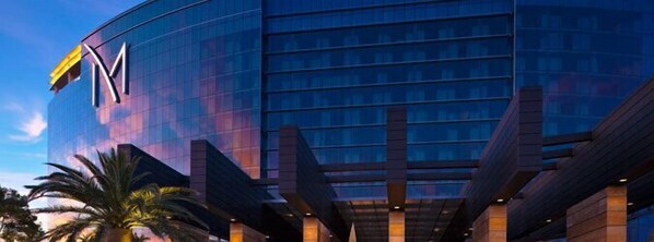 A modern hotel with a prominent 'M' logo, large glass windows, and a structured facade.