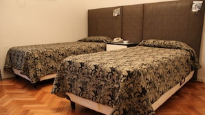 A hotel room with two single beds, a nightstand, and a telephone. - Ayacucho Palace Hotel (Buenos Aires)
