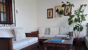 Un salon avec un canapé, une table basse et une plante en pot.