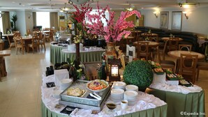 A buffet setup with various food items and a decorative centerpiece. - The Grand Dame Hotel (Iloilo)
