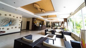 A spacious lobby with a reception desk, comfortable seating areas, and large windows offering views of the outdoors. - MO2 Westown Hotel Iloilo (Iloilo)