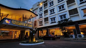 A hotel entrance with a sign reading "WESTON'S HOTEL" and a modern building facade with multiple windows and air conditioning units. - MO2 Westown Hotel Iloilo (Iloilo)