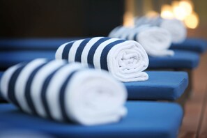 A row of neatly folded towels with striped patterns on blue cushioned seats. - Swiss-Belhotel Airport Jakarta (Tangerang)