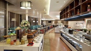 A buffet setup with various food items and a seating area with chairs and tables. - Swiss-Belhotel Airport Jakarta (Tangerang)