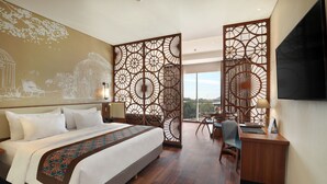 A hotel room with a large bed, a desk, and a view of the city. - Swiss-Belhotel Airport Jakarta (Tangerang)
