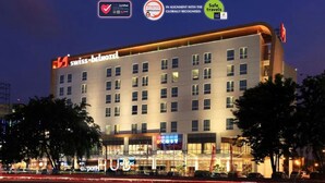 A hotel with a modern design, multiple floors, and a prominent sign for Swiss-Belmont. - Swiss-Belhotel Airport Jakarta (Tangerang)