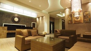 Eine moderne Lobby mit Empfangstresen, Sofas, einem Couchtisch und Wandbildern.